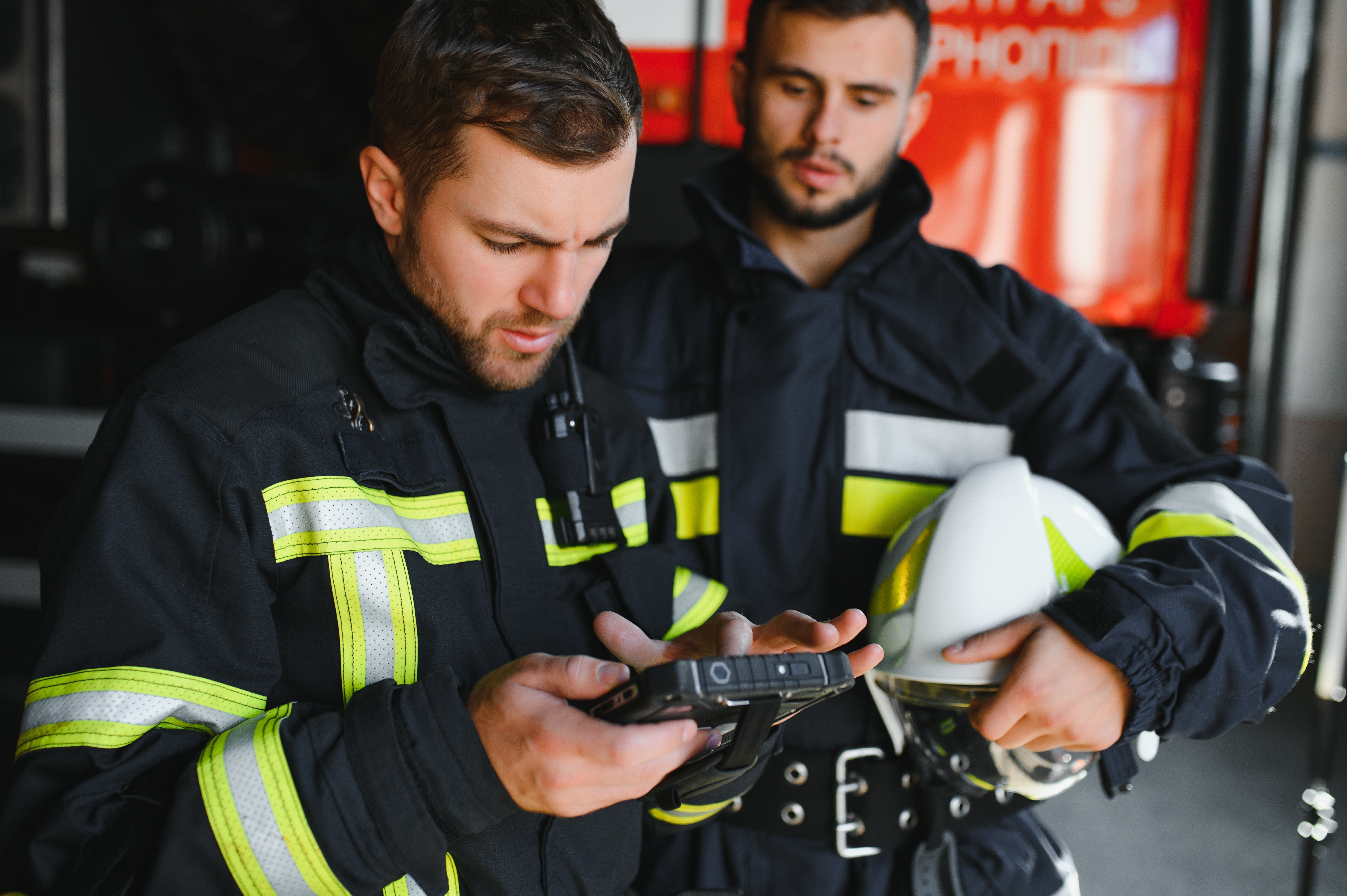 Image of two fireman looking at a computer.