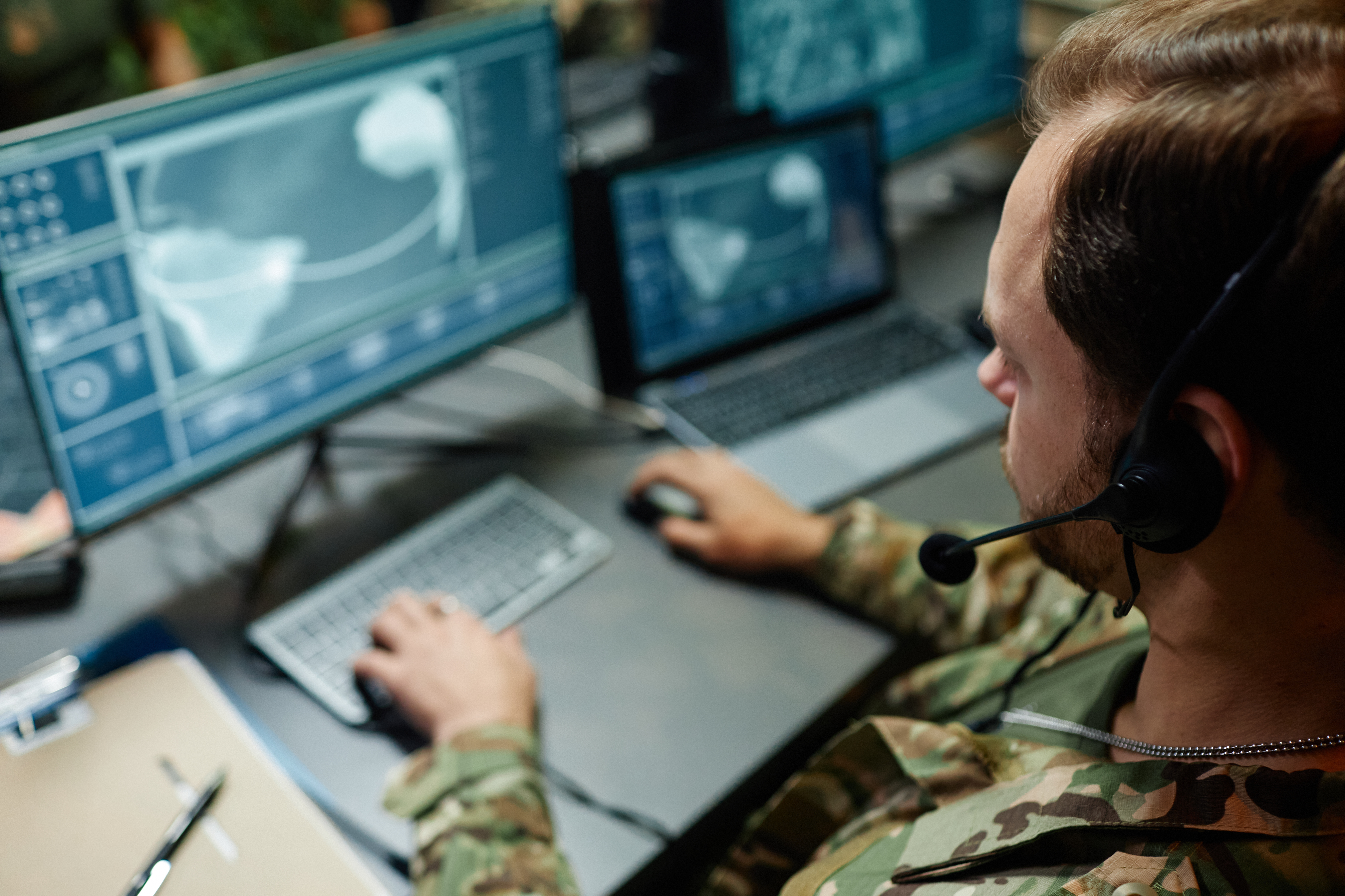 Solider wearing camouflage fatigues monitoring computers.