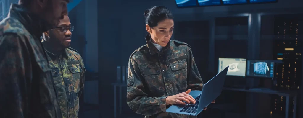 Three members of the US military looking at a laptop