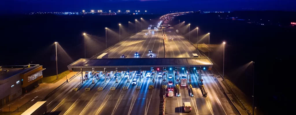 Overhead view of a 10 lane toll road pay station at night