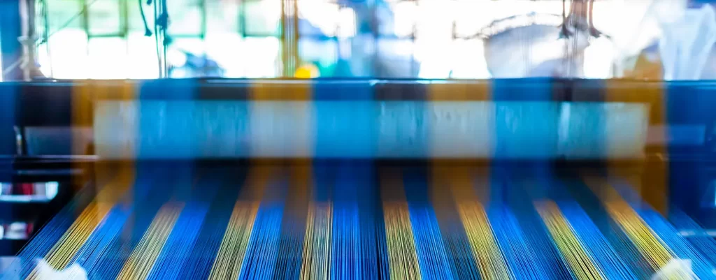 Close Up Hand Woven Cotton Weaver Machine Loom with Colorful Blue, Red, Yellow Silk Thread for made Fabric in Thailand