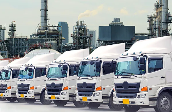 Fleet of trucks in front of petrochemical facility